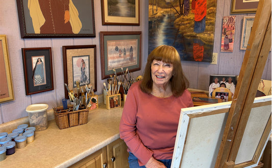 Jeanne happy behind her easel in her studio.
